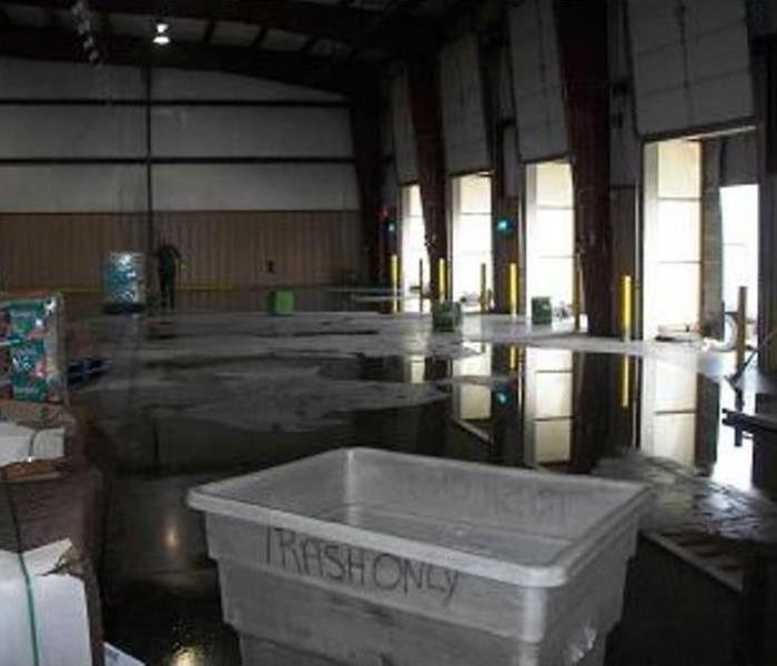 wet concrete pad, water visible, green equipment working in this warehouse