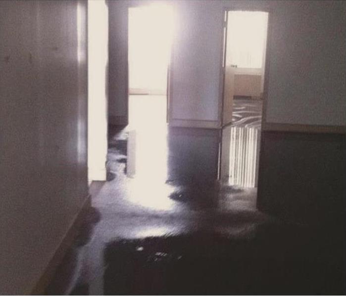 Water reflecting light off flooded carpet in several rooms