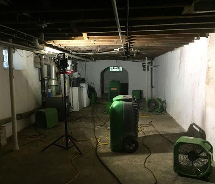 drying equipment in a basement, washer dryer and more in corner
