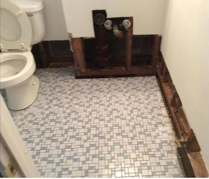 tiled bathroom, commode, and cut out walls 